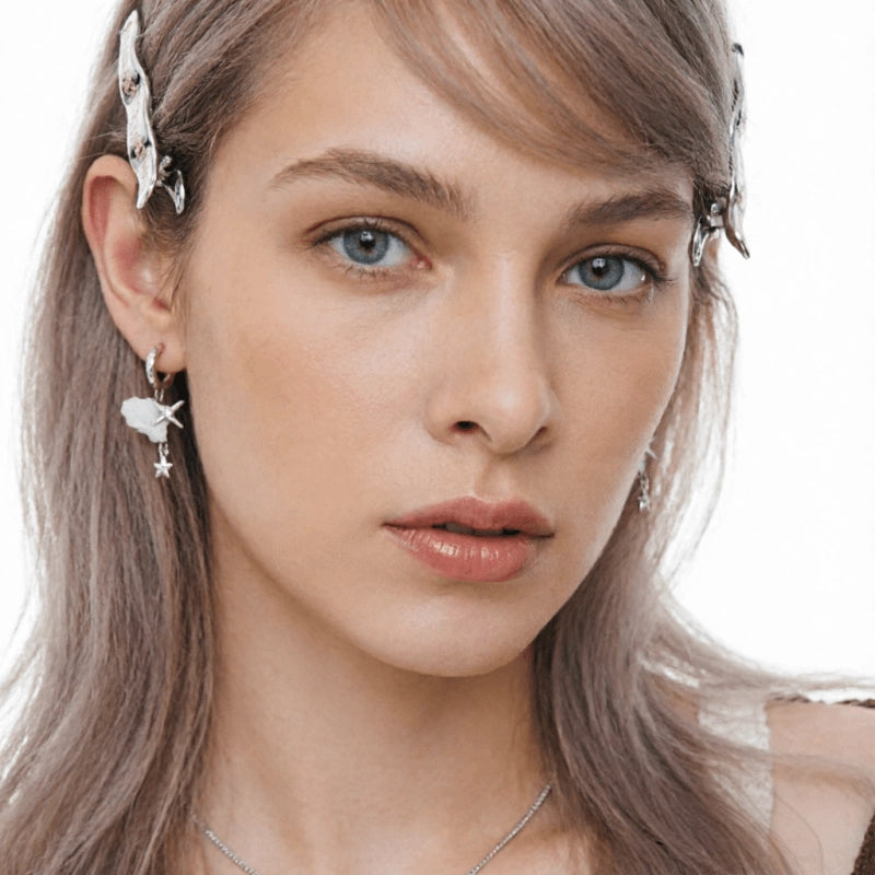 Close-up of a model wearing a white cloud earring with small silver-tone dangling stars.