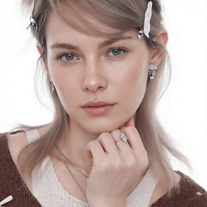 Front view of a model wearing white cloud and star earrings with a matching ring and necklaces.