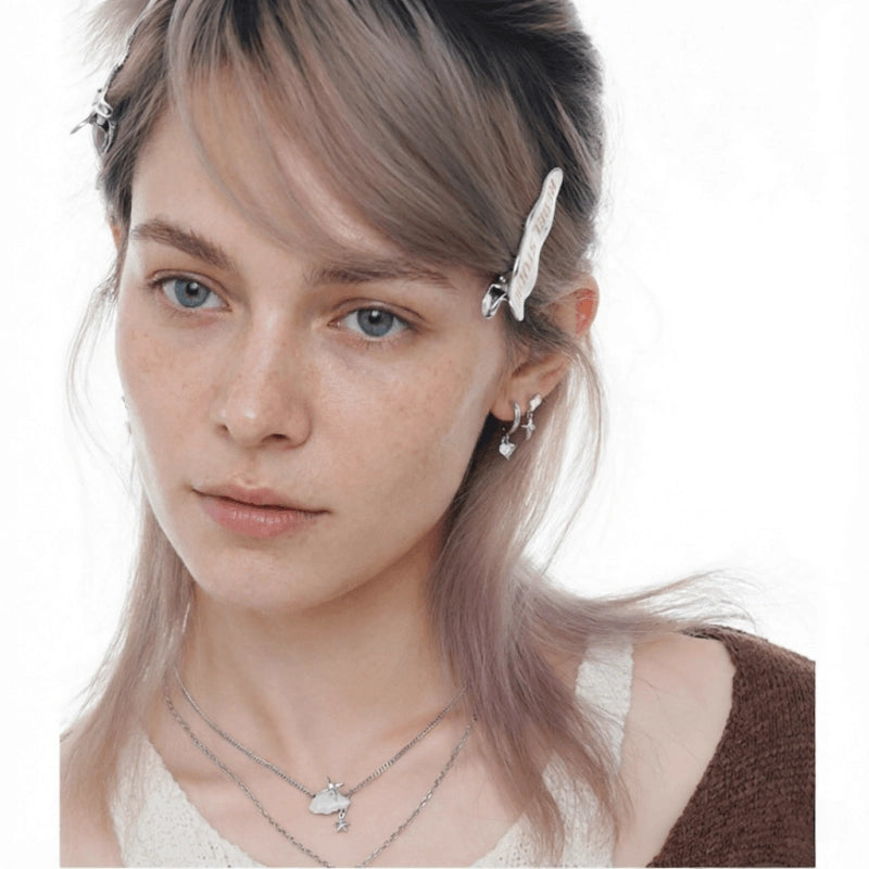Side view of a model wearing layered cloud-and-star necklaces and a matching silver-tone drop earring.
