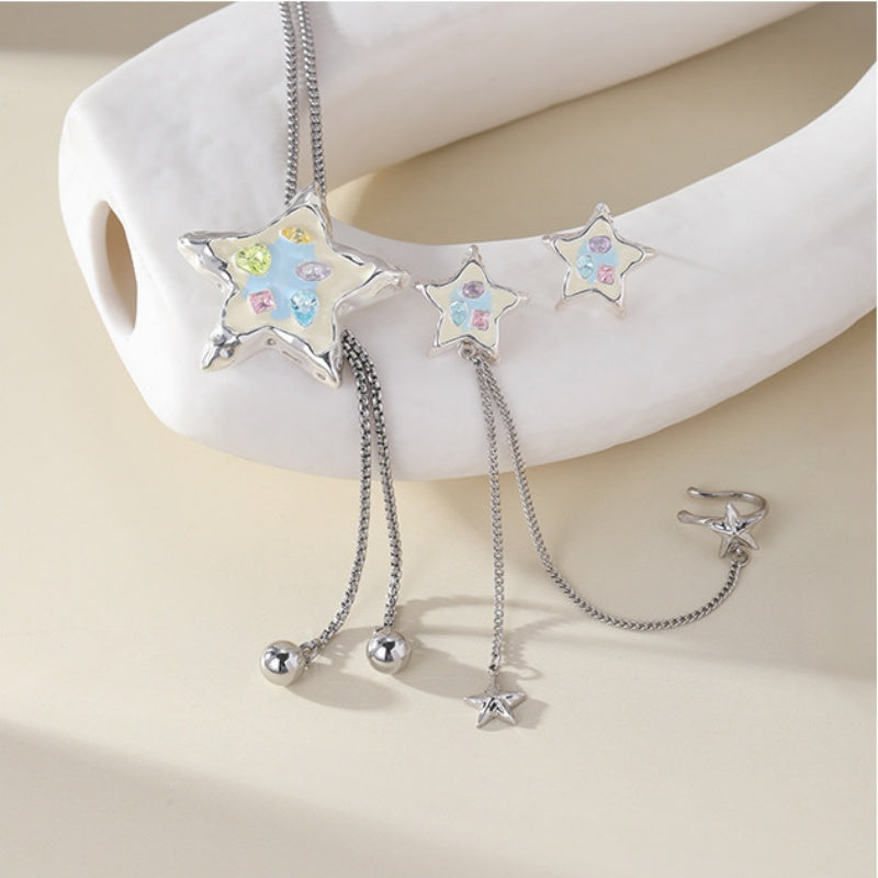 Pastel-detailed silver-tone star necklace and earrings displayed together, with dangling chains and small star charms.