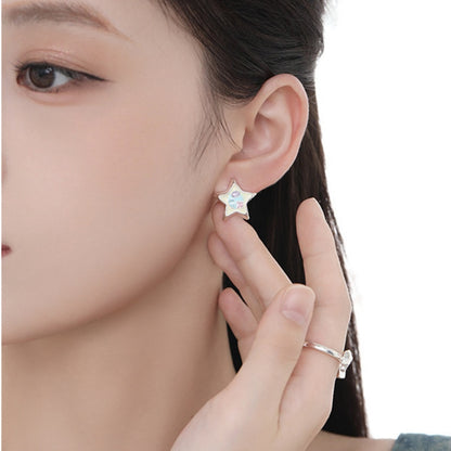 Close-up of a model wearing a silver-tone star stud earring with pastel-coloured details.