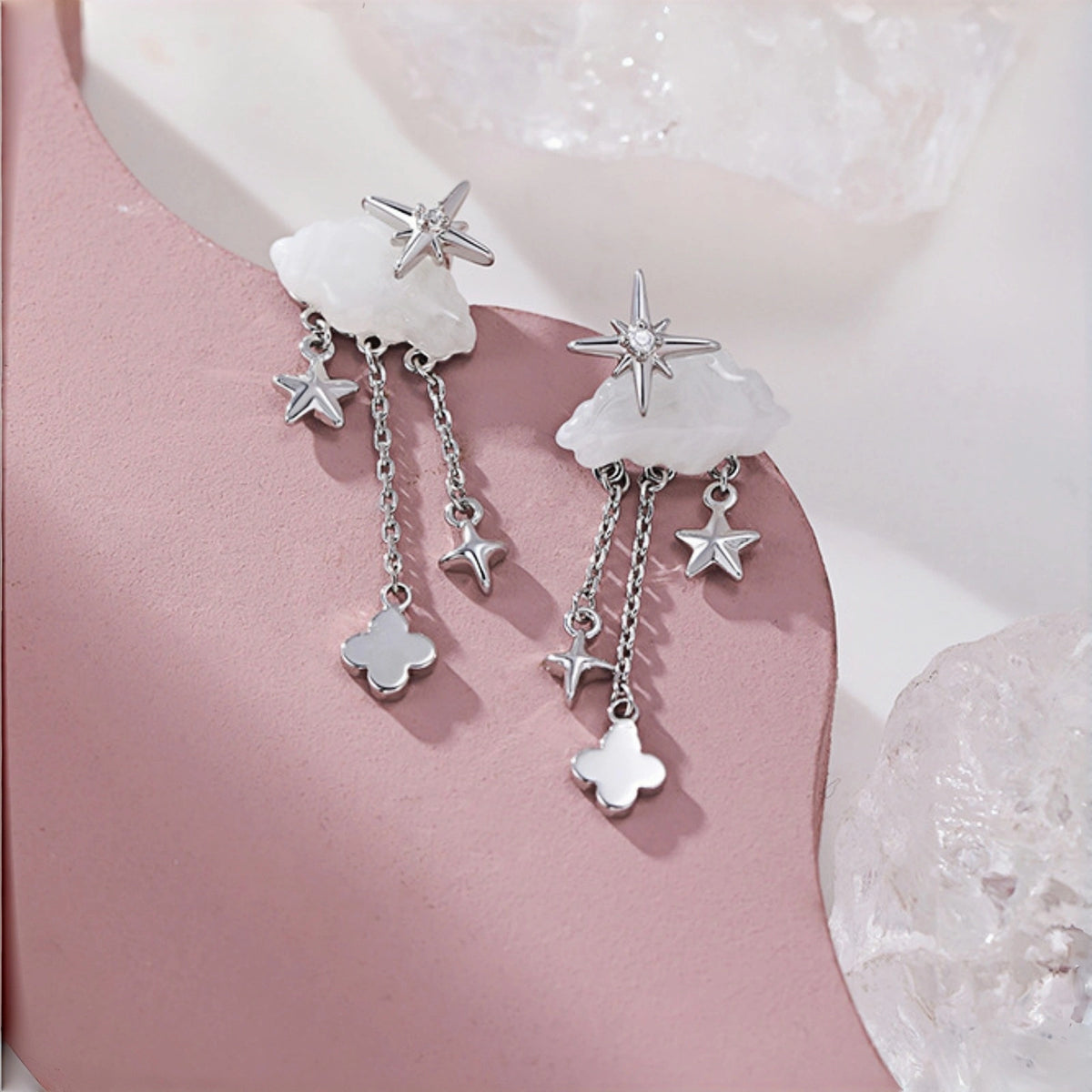 Cloud and star drop earrings close-up, mother-of-pearl clouds with star charms and dangling star and clover charms on chain