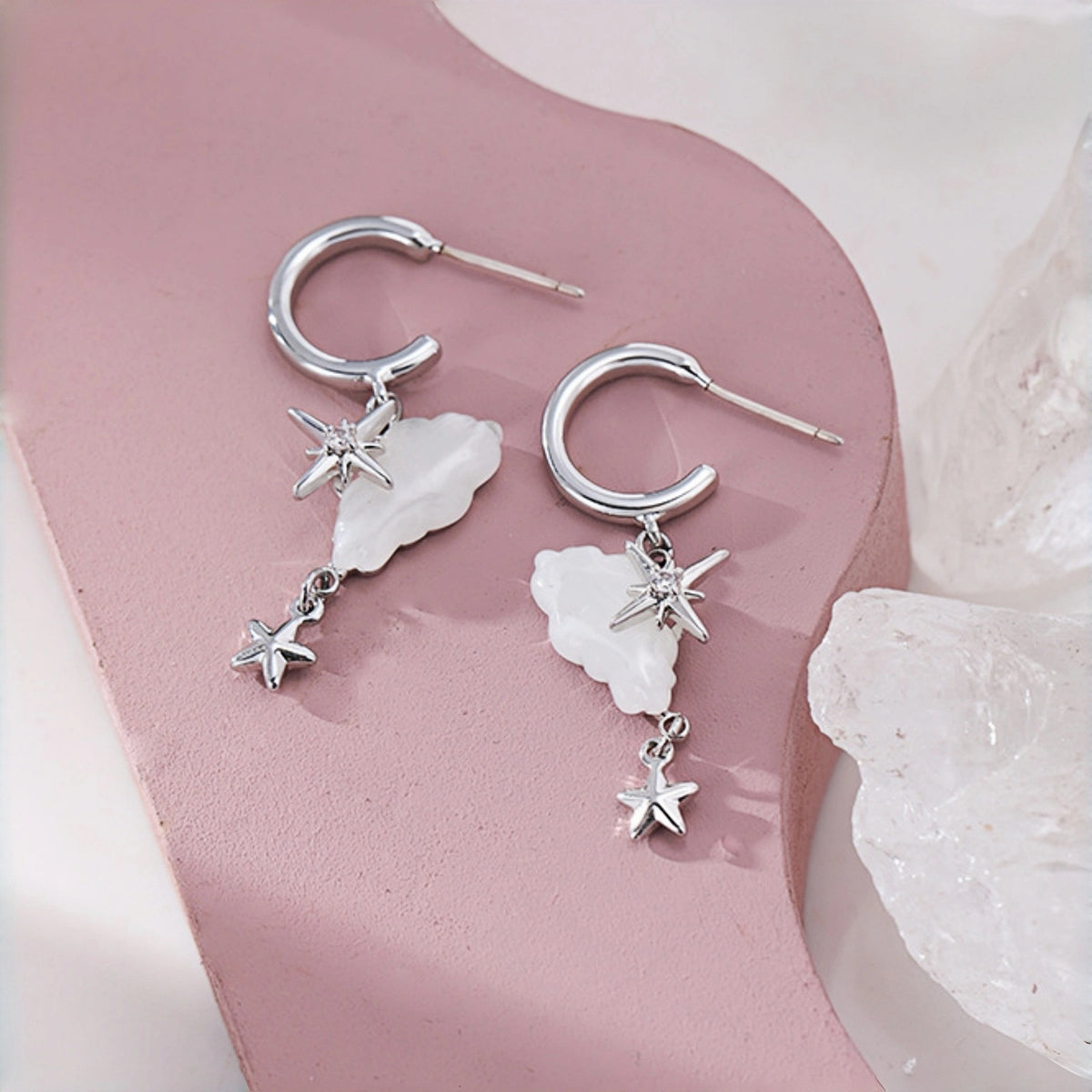 Cloud and star hoop earrings close-up, silver hoops with mother-of-pearl cloud charms and dangling star drops