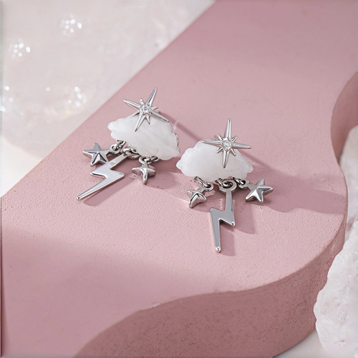 Cloud and star earrings close-up, silver star studs with mother-of-pearl cloud charms and dangling lightning bolt and star charms