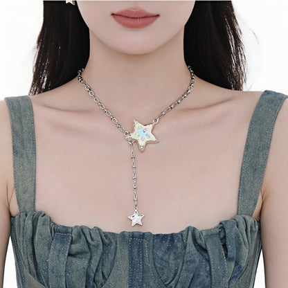 Front view of a silver-tone enamel star necklace with pastel-coloured details and a dangling smaller star, worn by a model.