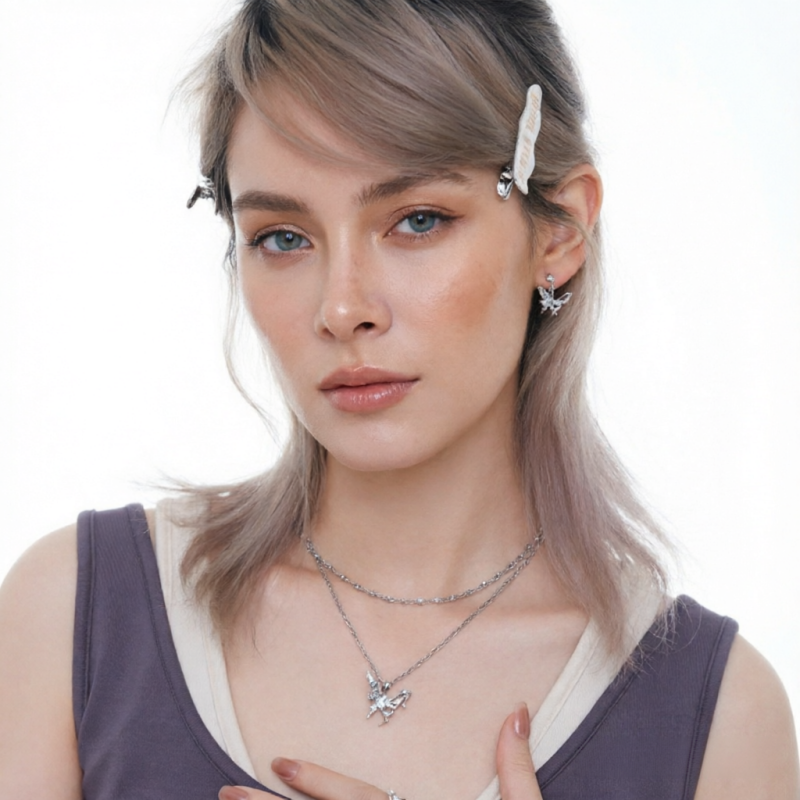Front view of a model wearing a butterfly pendant necklace and matching silver-tone butterfly earrings.