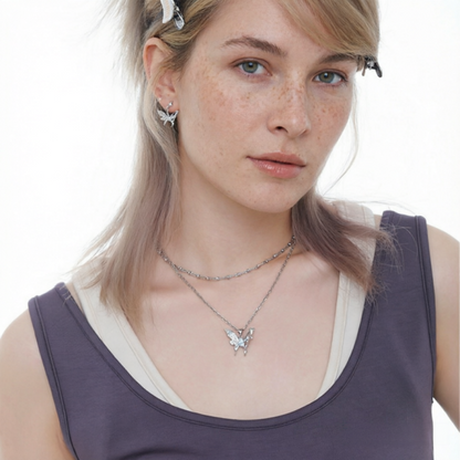 Model wearing a silver-tone butterfly pendant necklace and matching butterfly earrings.