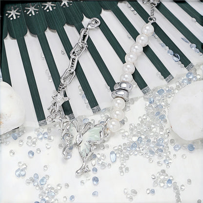 Fairy iridescent butterfly bracelet close-up, layered silver chain and pearl beaded bracelet with star and mint enamel butterfly charms, scattered with clear and blue crystal beads