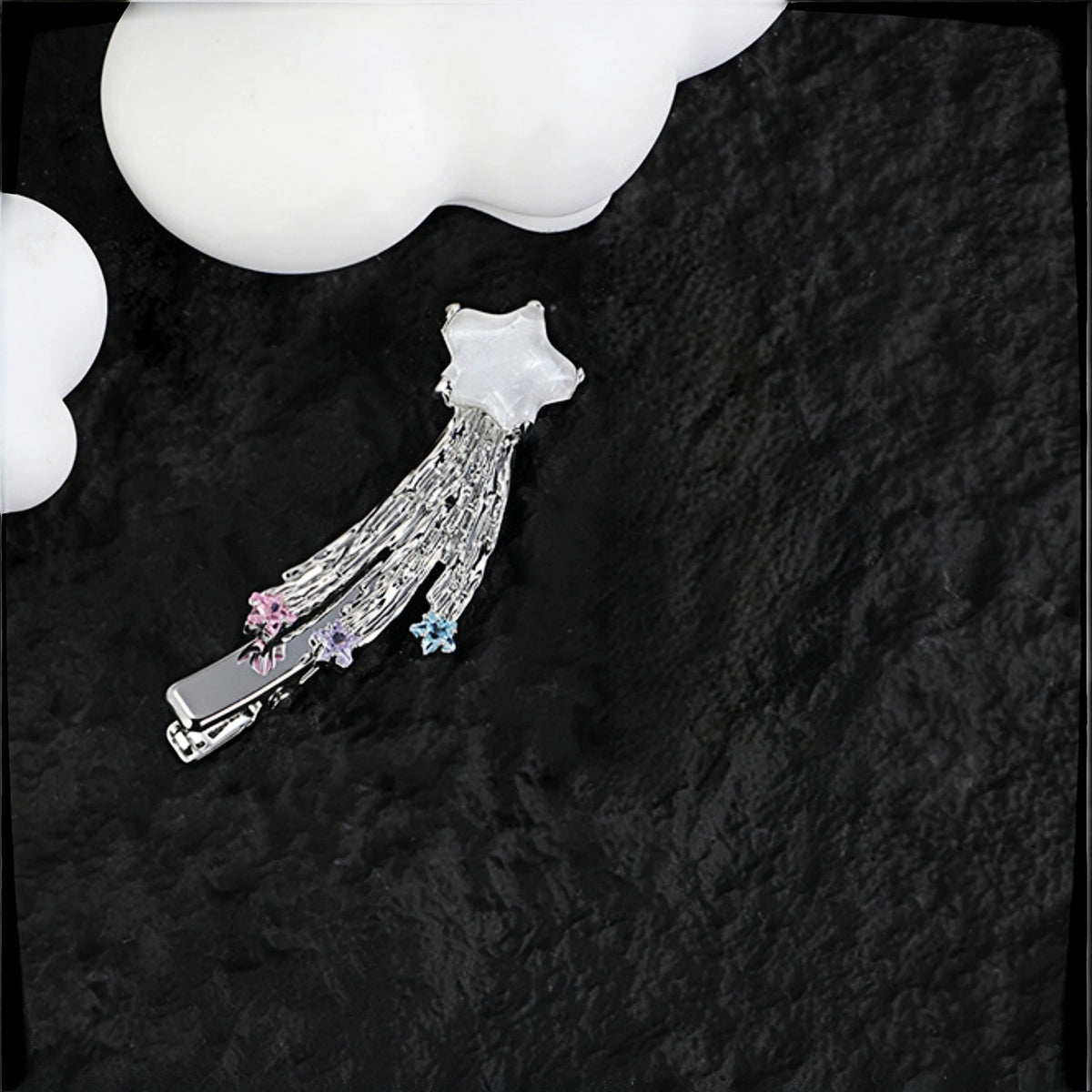 Fairy shooting star hair clip close-up, silver star charm with tasselled strands and pink, purple and blue crystal star drops