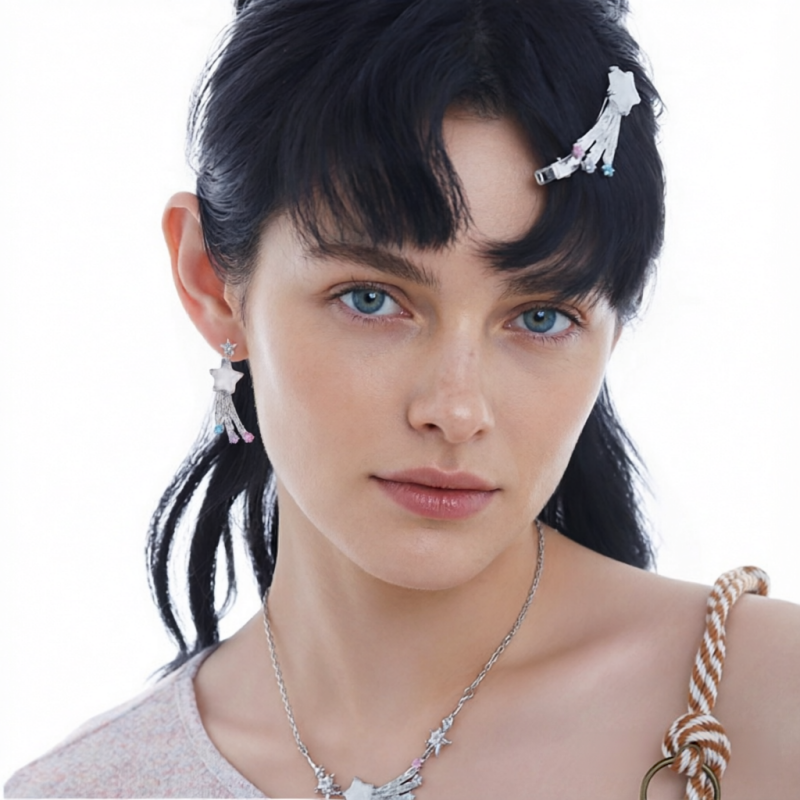Model wearing white shooting-star drop earrings and a matching star necklace with silver-tone trailing details.