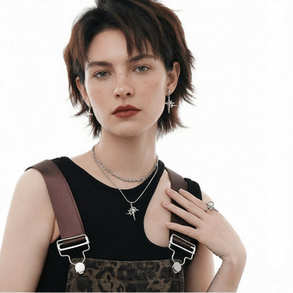 Model wearing silver-tone star drop earrings, a four-point star pendant necklace and a matching ring.
