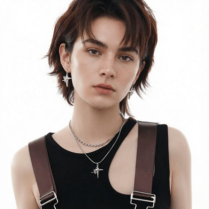 Model wearing silver-tone star drop earrings and a four-point star pendant on a fine chain.