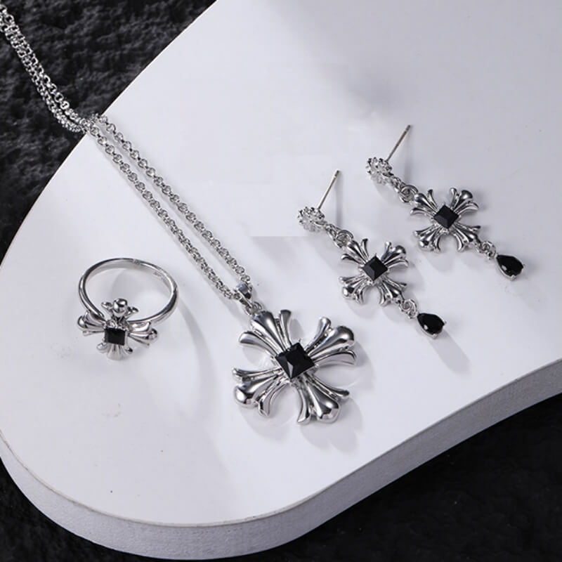 Silver-tone gothic cross necklace, drop earrings and ring displayed together, with black square centres and black teardrop earring charms.