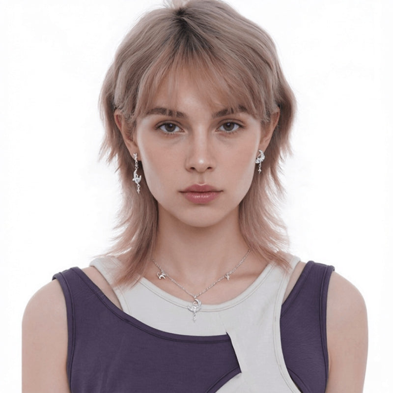 Front view of a model wearing silver-tone cat-and-crescent-moon earrings and a matching necklace.