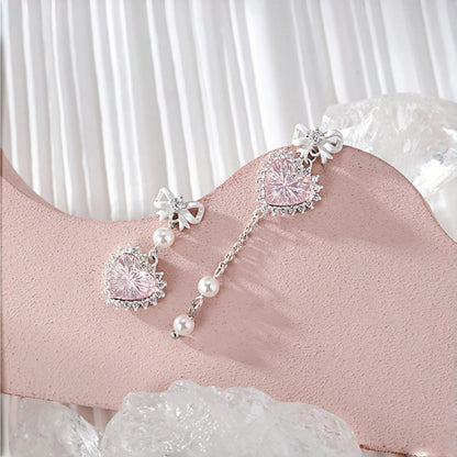 Pink heart princess earrings close-up, pair of pink crystal heart drops with clear crystal halos, topped with white enamel bow studs