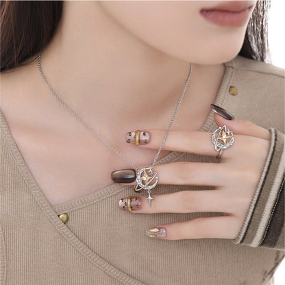 Model wearing a silver-tone planet pendant necklace with a dangling star and a matching orbital ring with gold-tone star centres.