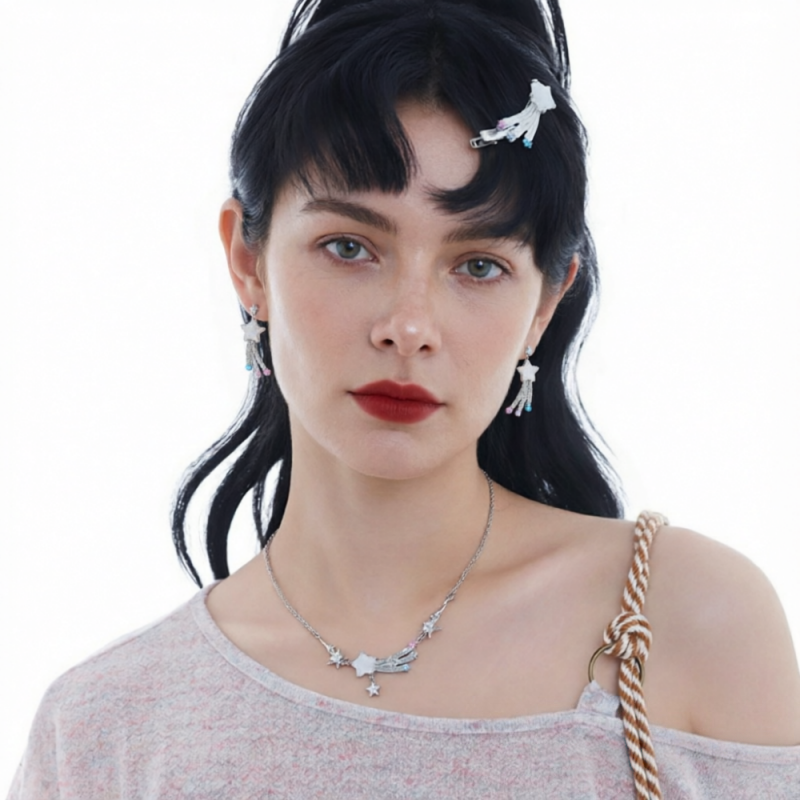 Model wearing white star earrings with trailing silver-tone details and a matching star necklace.