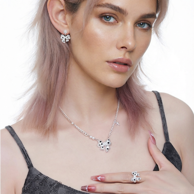 Model wearing a white bow necklace, matching earrings and ring with black star details.