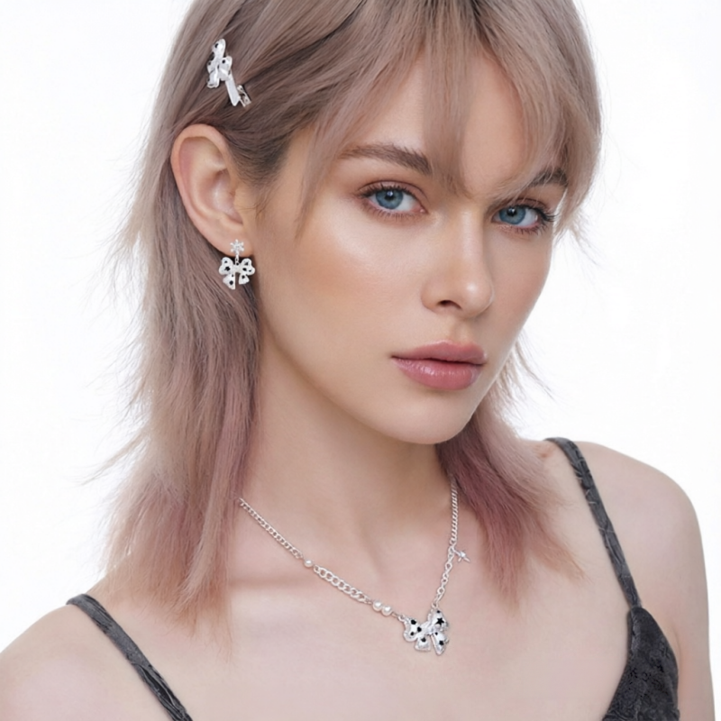 Model wearing a white bow pendant necklace and matching bow earrings with black star details.