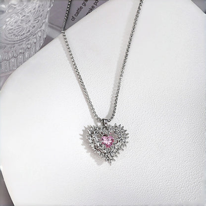 Thorned pink heart pendant necklace close-up, silver thorn-framed heart pendant with pink crystal centre stone on a box chain