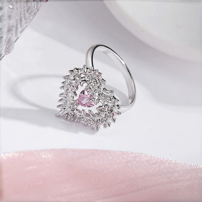 Thorned pink heart ring close-up, silver thorn-framed heart ring with pink crystal centre stone
