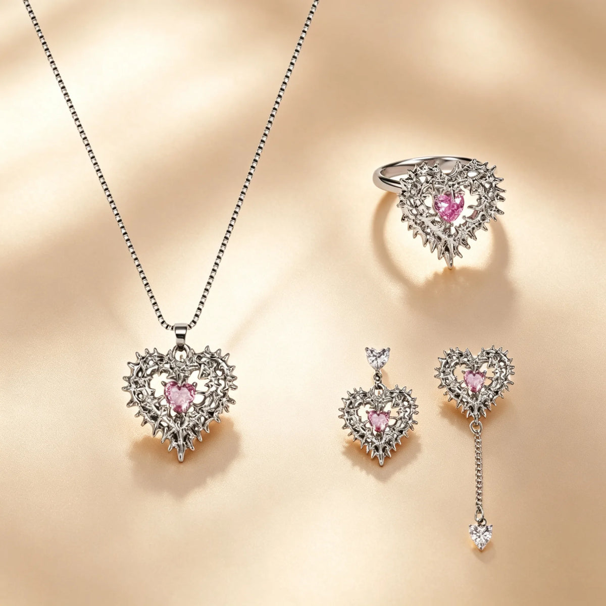 Thorned heart jewellery set with pink crystal hearts in silver thorn frames, ring, mismatched drop earrings and necklace