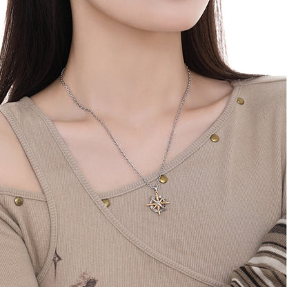 Model wearing a two-tone starburst pendant necklace with gold-tone rays inside a silver-tone orbital frame.