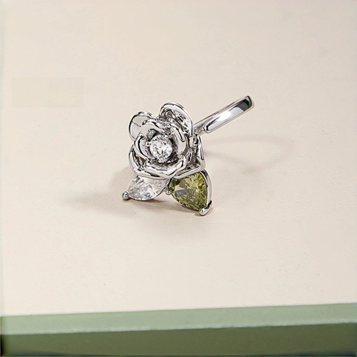 Vintage 3D rose ring close-up, open silver ring with a 3D rose charm featuring a clear crystal centre and clear and olive green crystal leaves