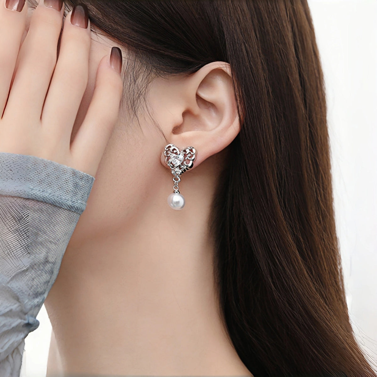 Model wearing vintage lace heart drop earring, silver filigree heart stud with dangling pearl charm