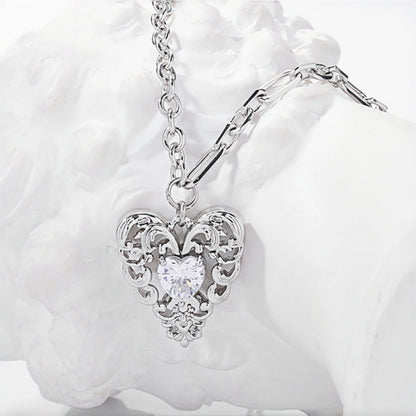 Vintage lace heart pendant necklace close-up, silver filigree heart pendant with clear heart-shaped crystal on a double chain
