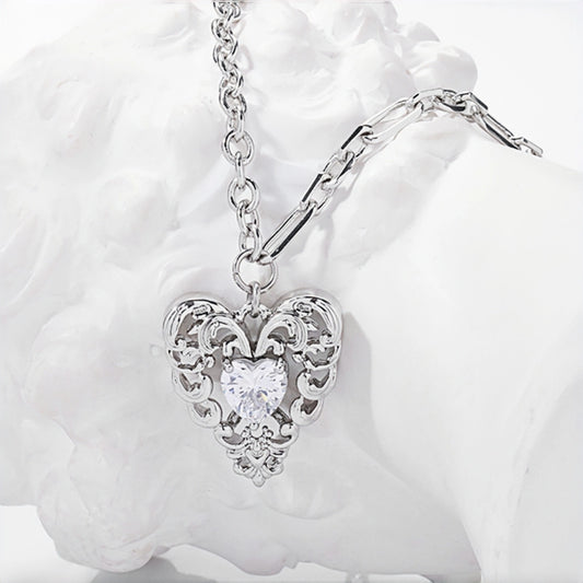 Vintage lace heart pendant necklace close-up, silver filigree heart pendant with clear heart-shaped crystal on a double chain