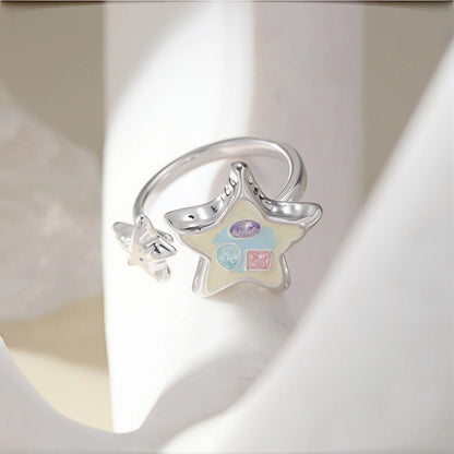 Enamel star ring close-up, open silver ring with an enamel star charm featuring pastel crystals and a small star accent