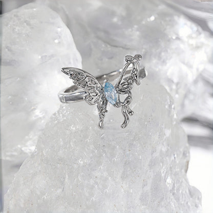 Fairy butterfly ring close-up, open silver filigree butterfly ring with a marquise blue crystal centre, on a crystal rock
