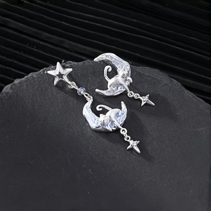 Moon and cat earrings close-up, pair of silver crescent moon drop earrings with cat charms, star studs and star drops